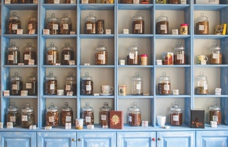 apothecary shelves filled with glass jars full of dried herbs for herbs for acne.