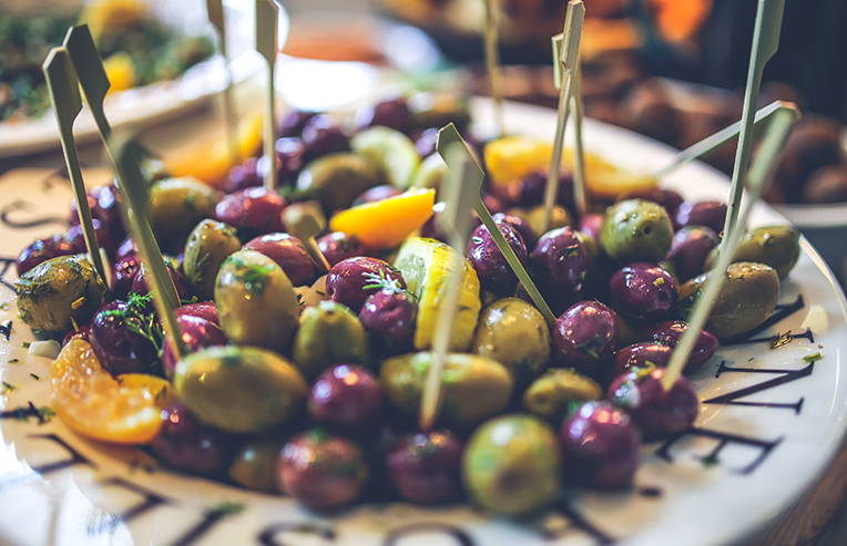 a plate of green and purple olives to eat for perimenopause