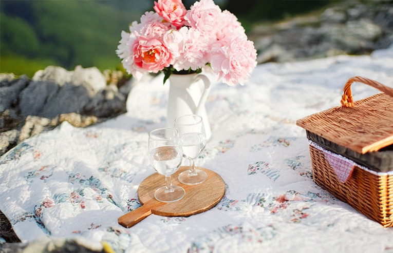 A couple of wine glasses on a wooden board with a vase of pink peonies featured image for PCOS phenotypes