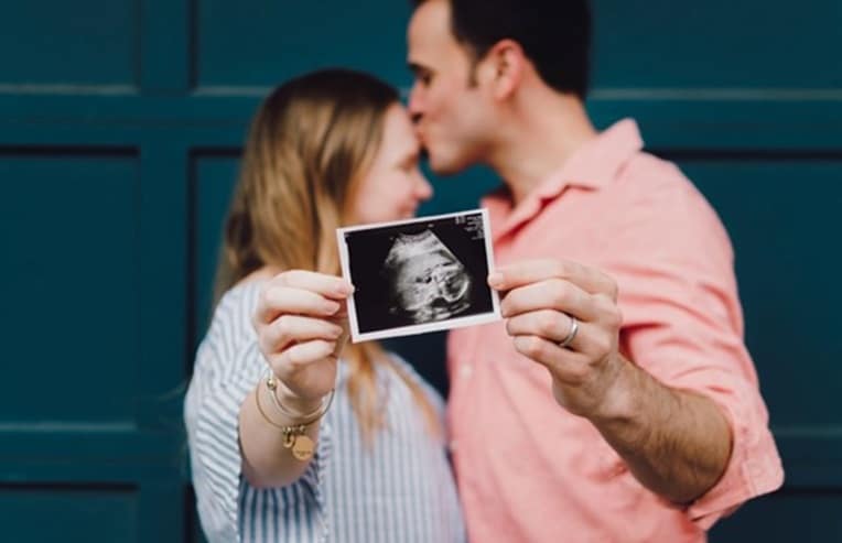 couple holding ultrasound picture, preconception guide to pregnancy