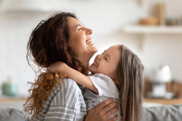 Mom and daughter hugging and laughing