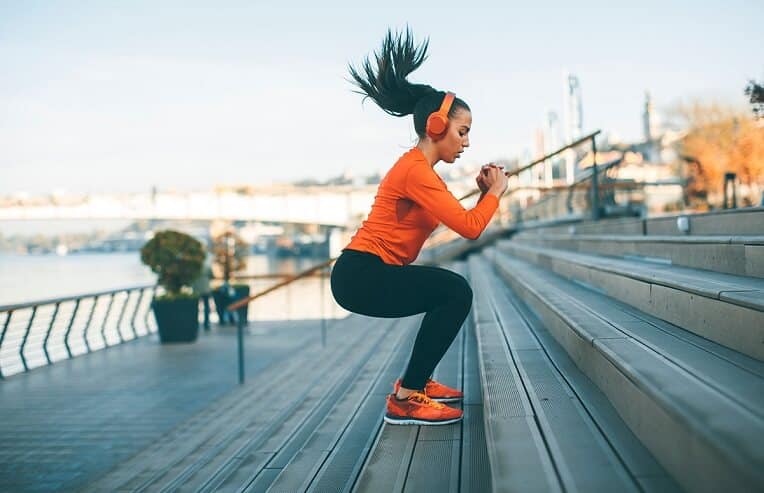 woman jumping up a step outside for exercise, muscle mass blog