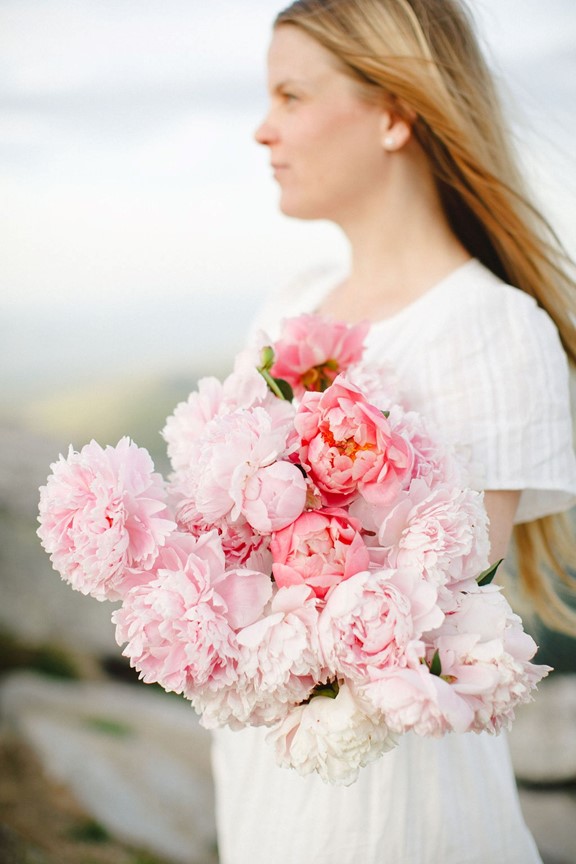 A woman holding a bouquet of pink flowers taking steps toward her PCOS phenotypes
