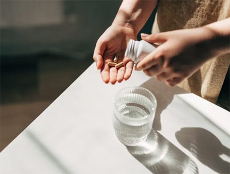 Woman dispensing vitamins into her hand