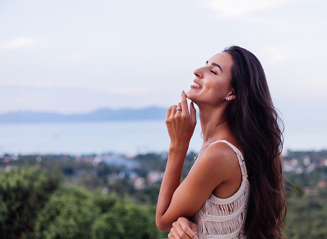 Woman relaxed with water in the background.